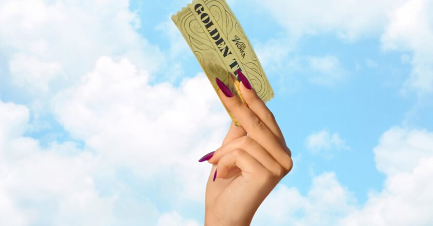 Mão erguendo o Bilhete Dourado de Willy Wonka contra um céu azul com nuvens, em referência ao reality show Wonka: O Bilhete Dourado da Netflix.