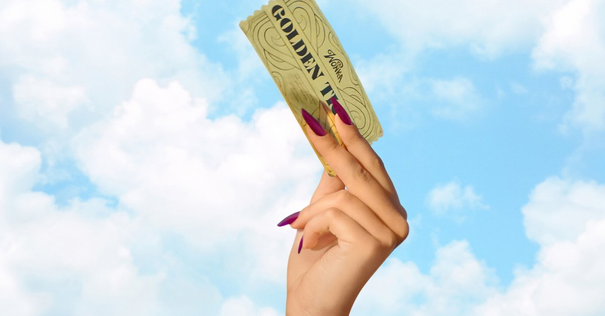 Mão erguendo o Bilhete Dourado de Willy Wonka contra um céu azul com nuvens, em referência ao reality show Wonka: O Bilhete Dourado da Netflix.